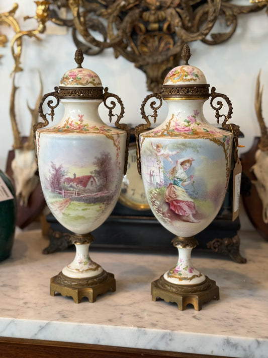 Pair of Antique Enhanced Hand-Painted Sèvres-Style Porcelain Lidded Urns with Ormolu Mounts